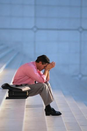 man sitting on steps with his head in his hands